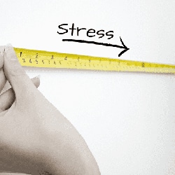 Das Bild zeigt eine Hand die ein abfallendes Maßband hält, dass eine Reduktion von Stress suggeriert