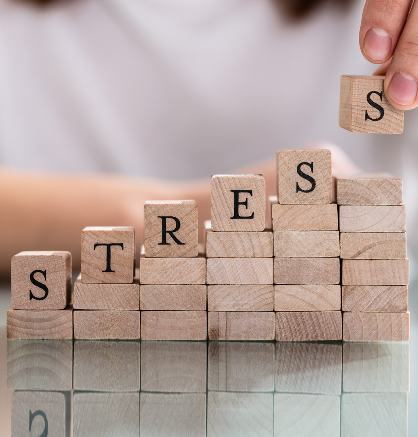 Ein Turm aus Holzklötzen wird gebaut, auf dem das Wort "Stress" zu sehen ist