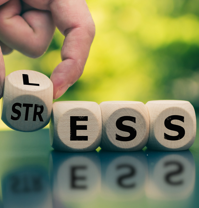 Würfel, die das Wort STRESS bilden und zu LESS umgebaut werdemn